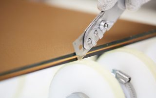 nahansicht-eines-messers-das-die-kante-eines-flachglases-bearbeitet