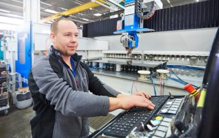 mitarbeitert-steuert-eine-maschine