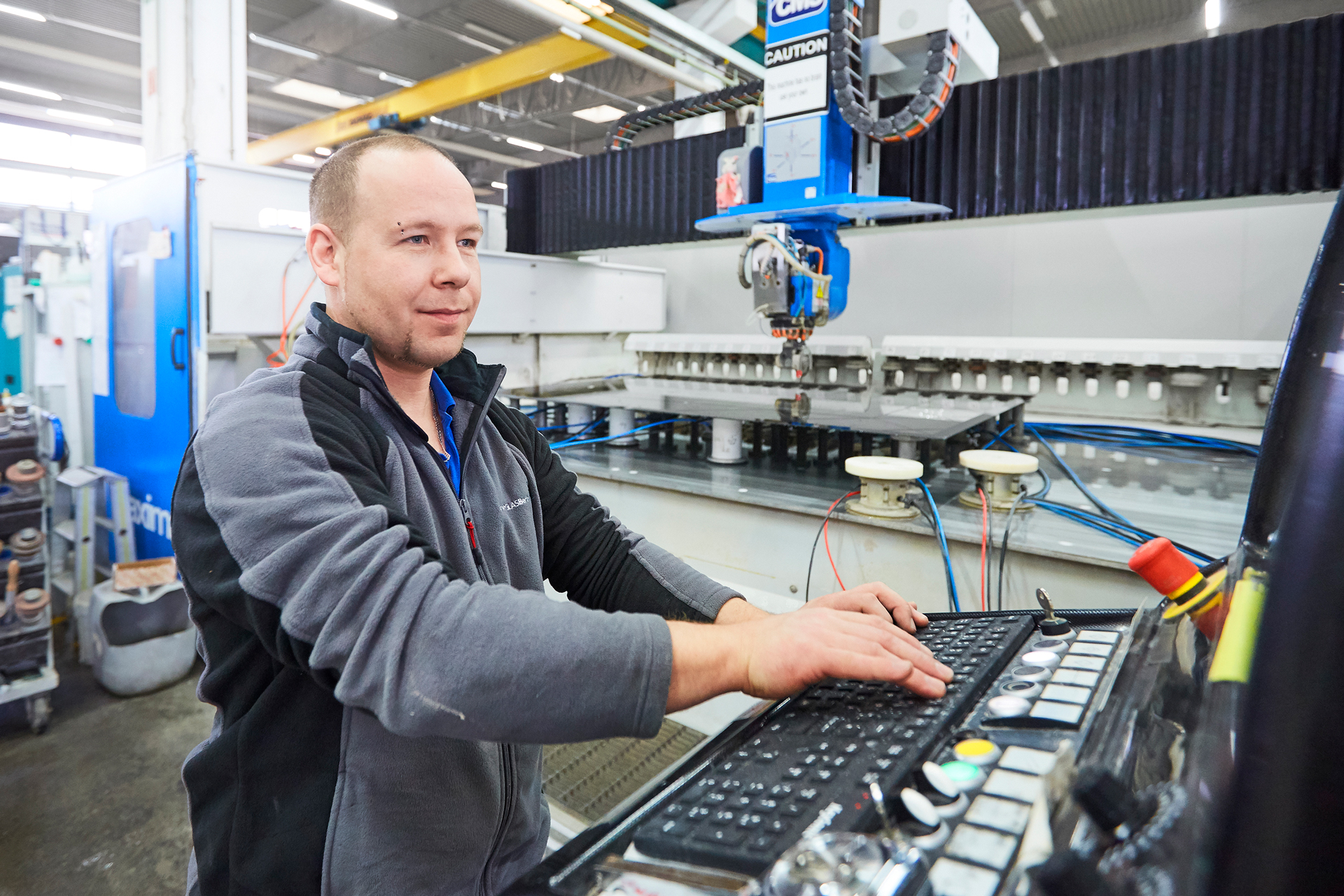 mitarbeitert-steuert-eine-maschine