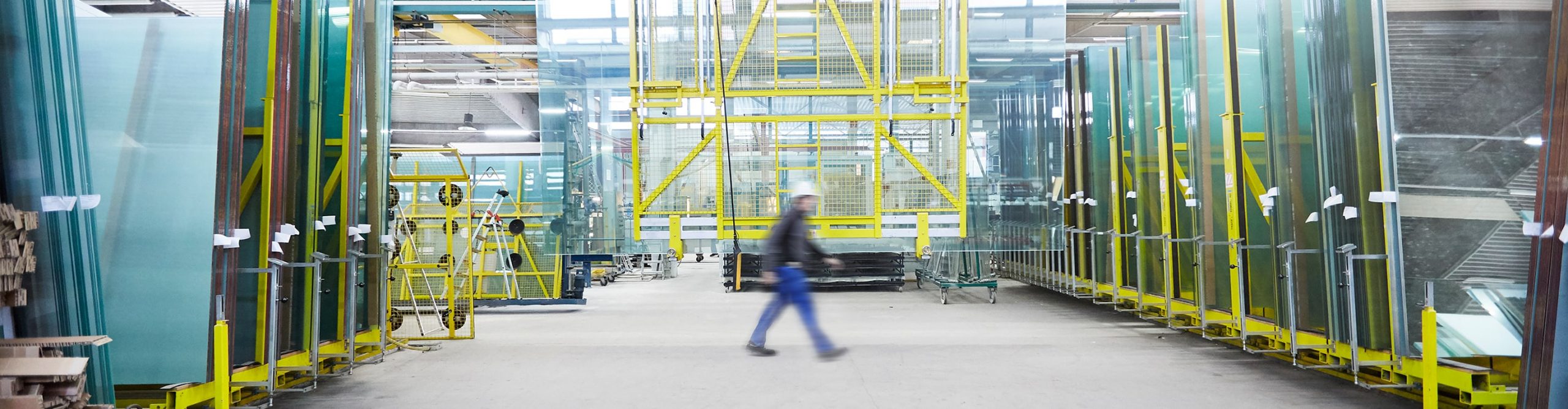 ueber-uns ein-mitarbeiter-geht-durch-die-produktionshalle